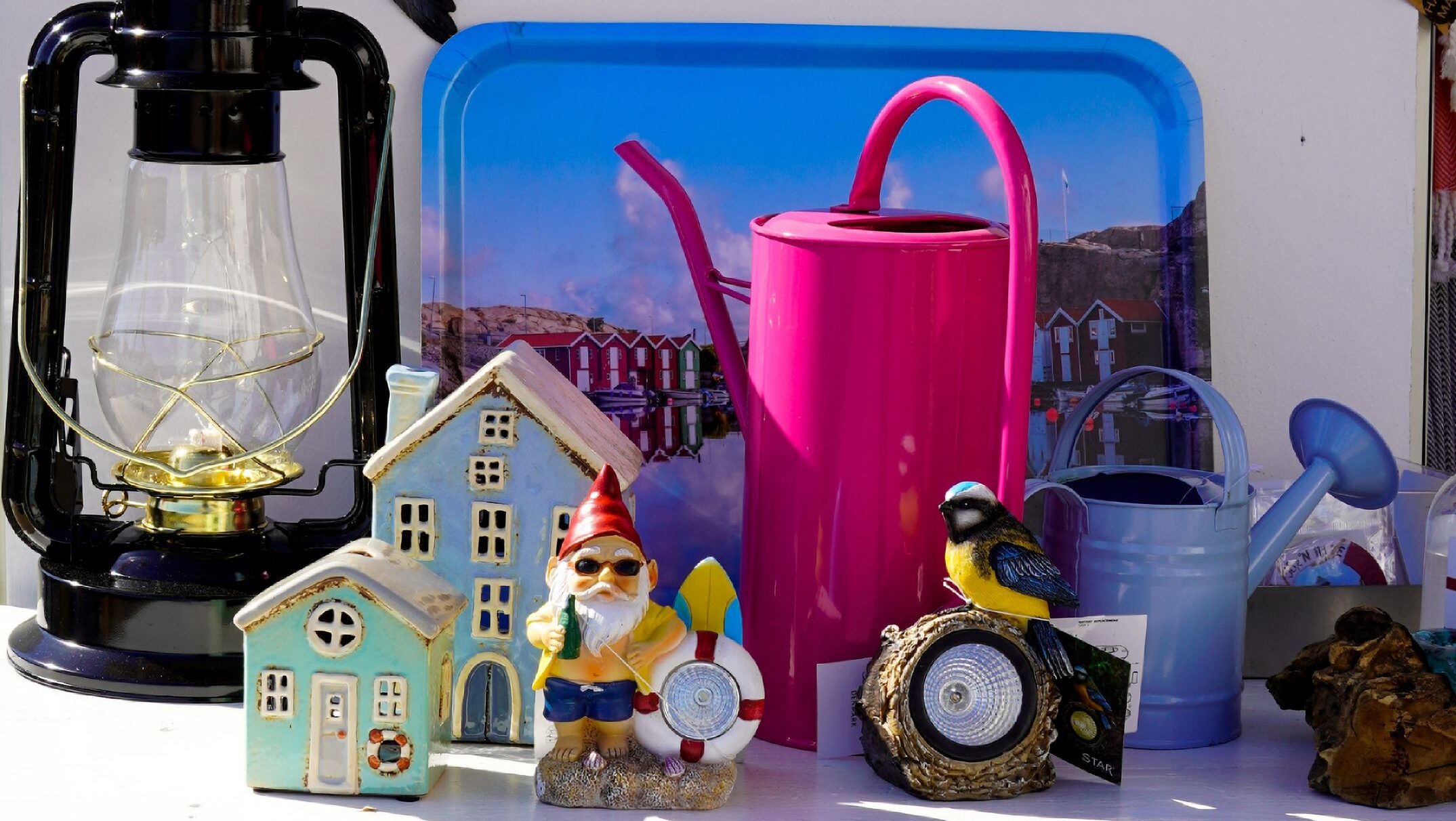 A vibrant market display featuring various figurines, decor items, and gardening tools.